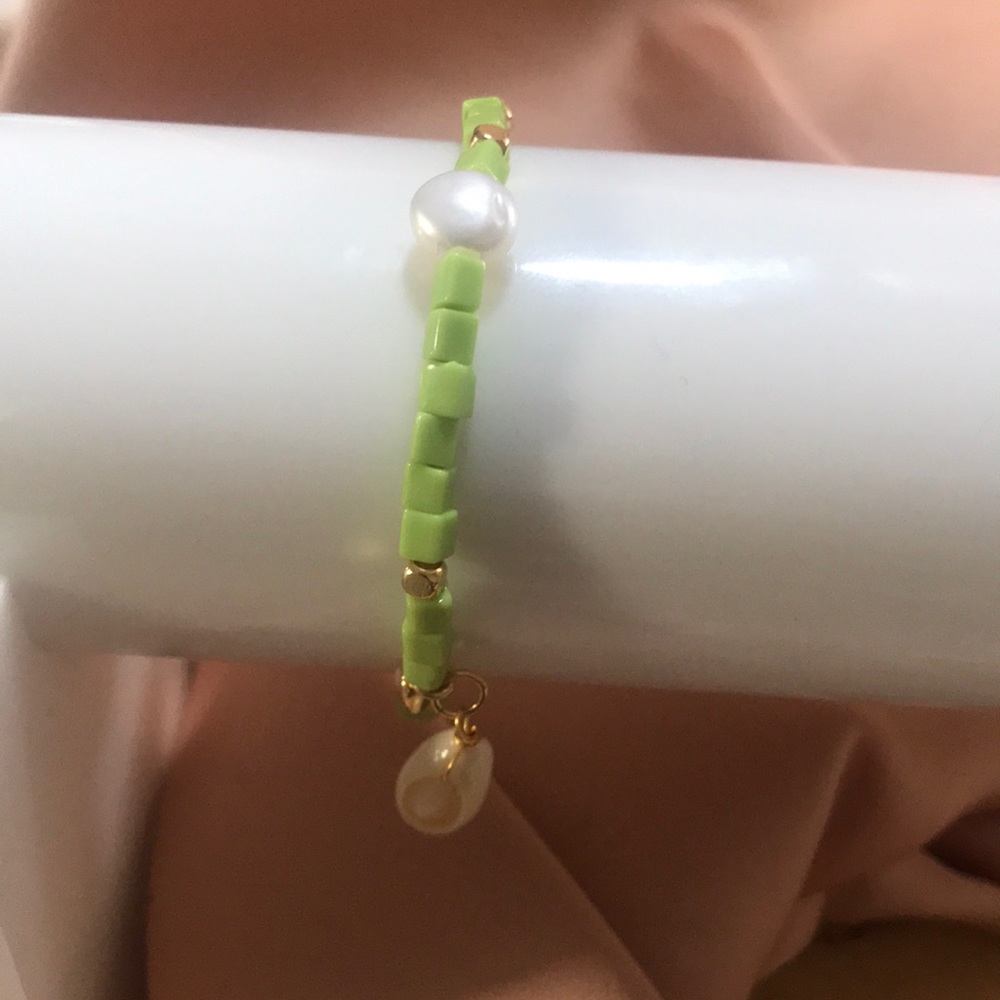 Mayamar charm bracelet w/a shell, pearl, gold circle stretches from 4-7 inches.